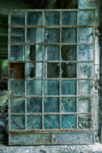 Eine alte Sprossentür mit teils zerbrochenen Fenstern
