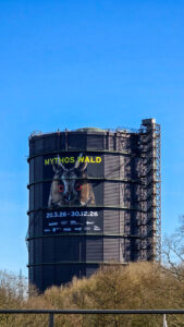 Gasometer von außen mit Ausstellungsplakat