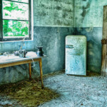 Ein Raum mit Tisch und altem Kühlschrank