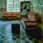 in Raum mit karierten Kachekn, altem Sofa und Holztruhe