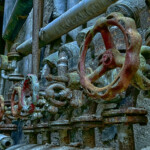 Viele Ventilräder an einer Wand, rostig