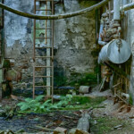 Eine Leiter und ein Tank an der Wand der alten Fabrikhalle