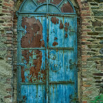 eine blau-rostrote Außentür mit Rundung oben