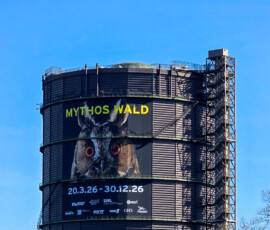 Gasometer von außen mit Ausstellungsplakat